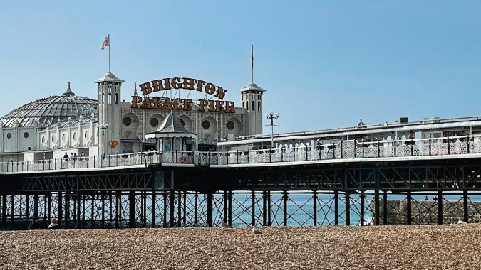 Brighton Pier, England - image by Nick Fewings on Unsplash https://unsplash.com/photos/a-pier-on-a-beach-with-a-blue-sky-in-the-background-TefuwyhN7ws